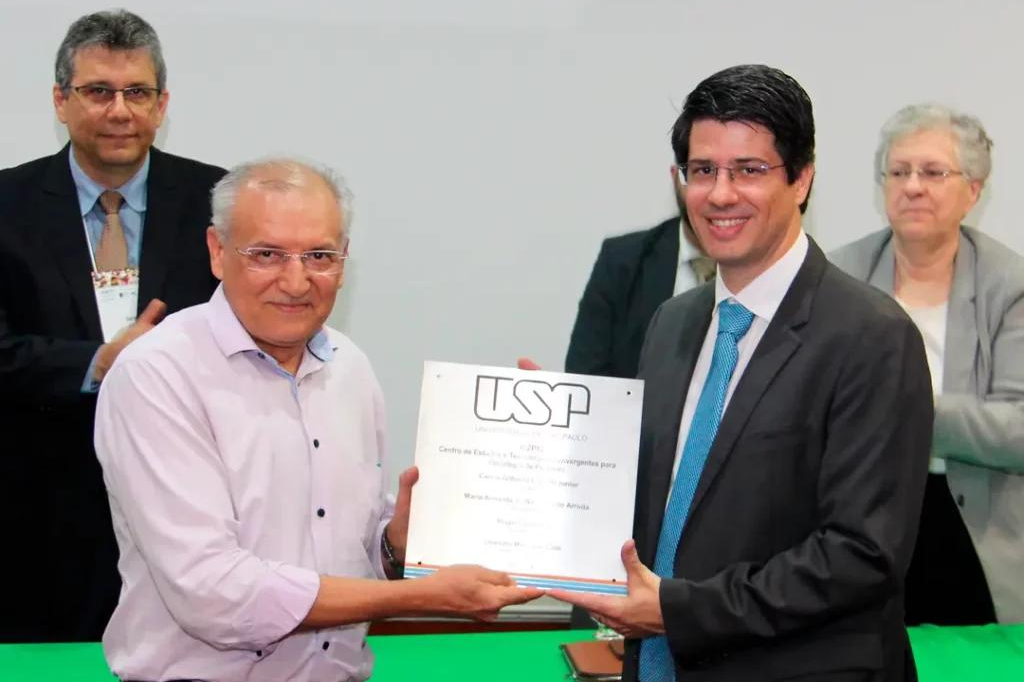 Professores Leandro Machado Colli e josé Sebastião dos Santos posam com a placa de inauguração do C2PO em Ribeirão Preto.